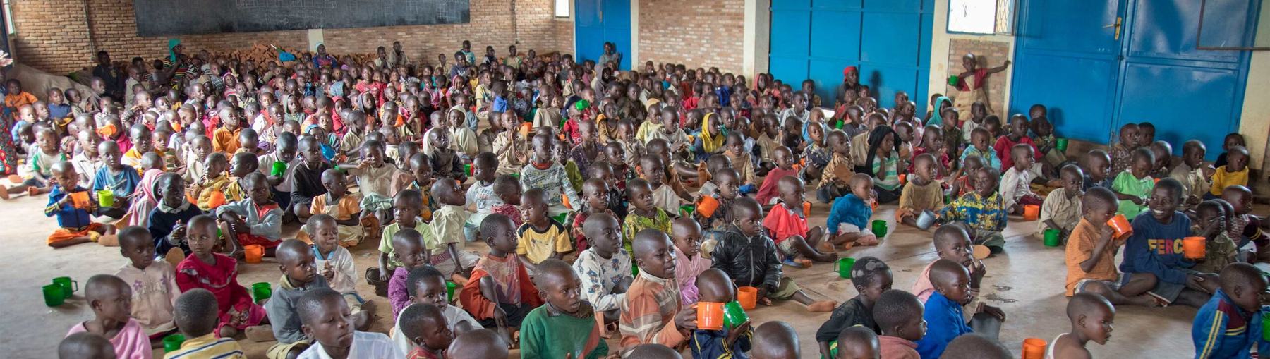Children holding cups at a Communities of Hope feeding point
