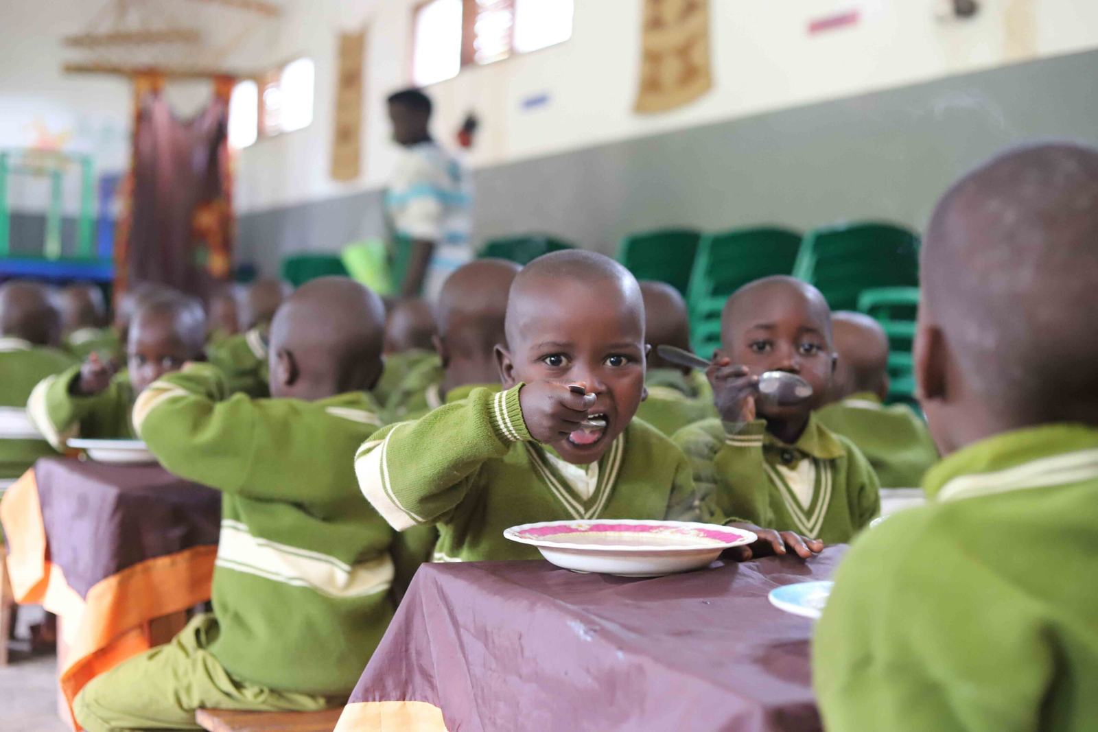 Children in school uniform eating fortified porridge